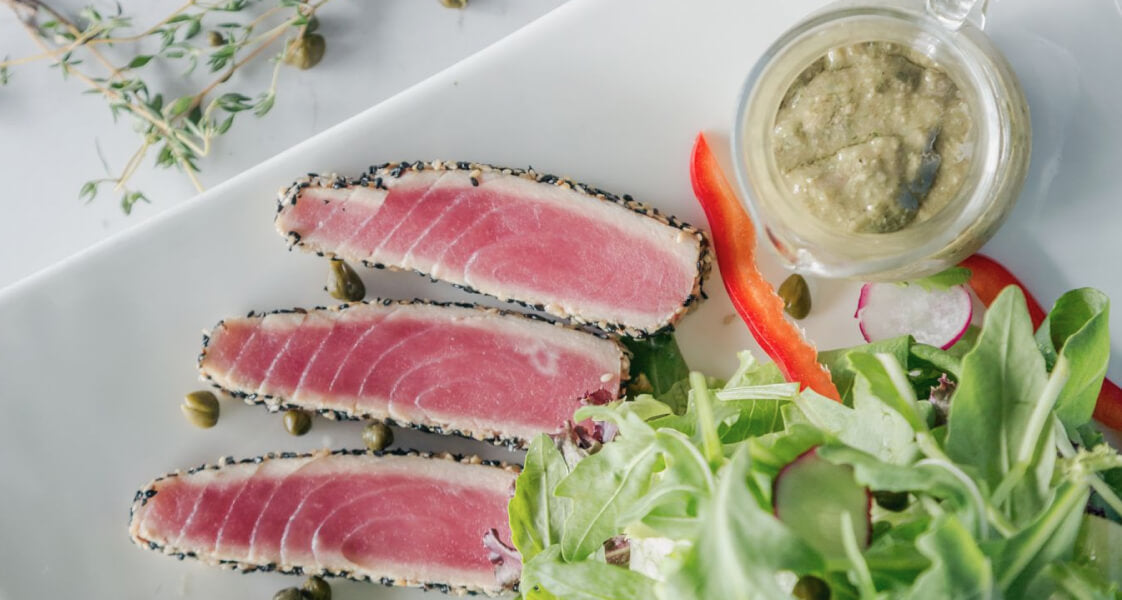 Plate of seared sesame-crusted tuna with fresh greens, an omega-3 food for healthy hair
